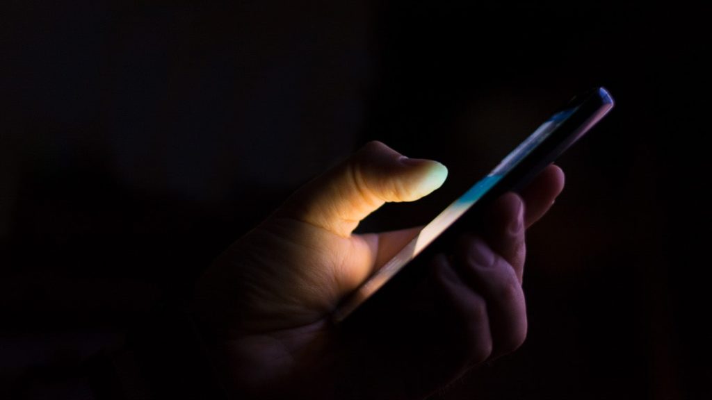Person holding smartphone with VPN
